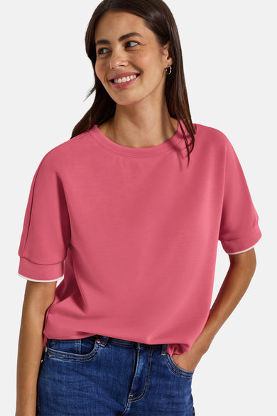 Top met korte mouwen koraal van STREET ONE, gedragen met een blauwe jeans en oorringen.