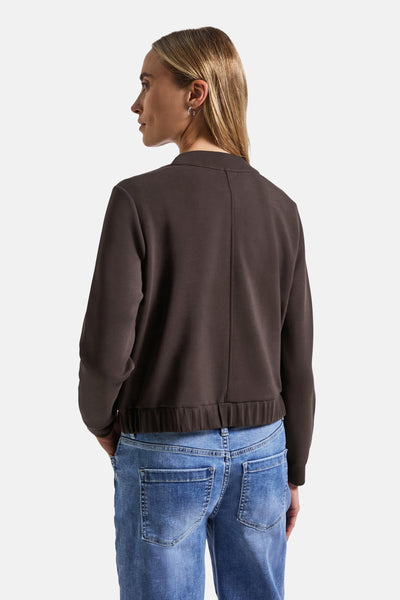 Bruine Street One vest, gedragen met een blauwe spijkerbroek, achterzicht.