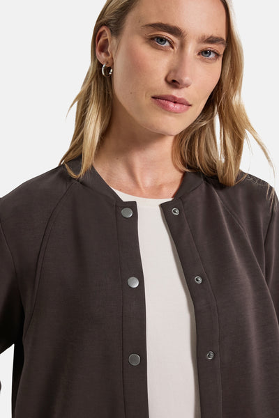 Bruine STREET ONE gilet met drukknoopsluiting, gedragen over een crèmekleurige top.