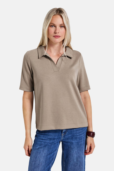Top met korte mouwen beige van Street One, gedragen met een blauwe jeans en een bordeauxrode armband.