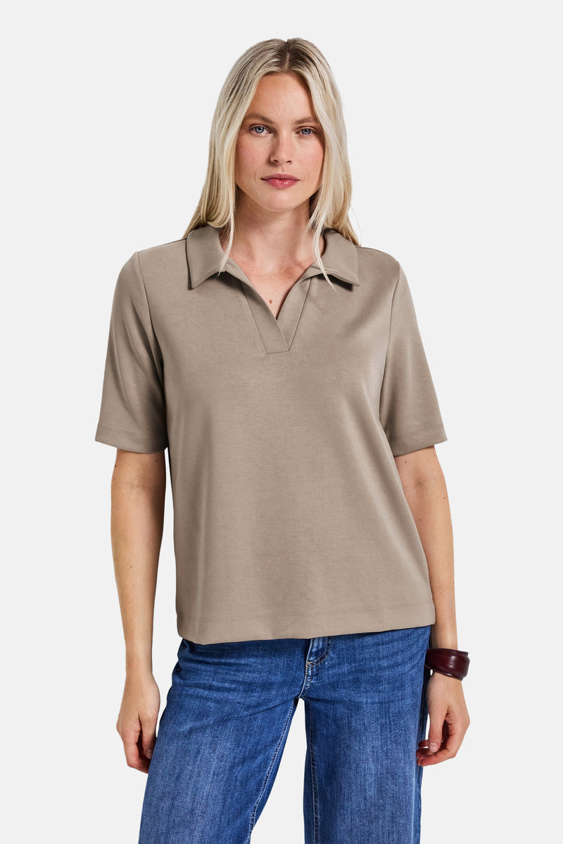 Top met korte mouwen beige van Street One, gedragen met een blauwe jeans en een bordeauxrode armband.
