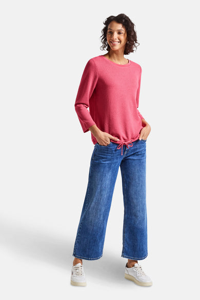 Pull col rond corail de Street One, porté avec un jean et des baskets blanches.