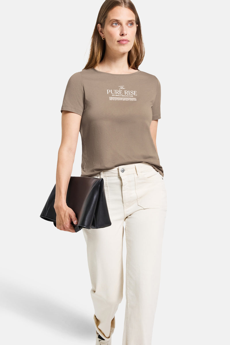Beige T-shirt met korte mouwen van STREET ONE, gedragen met een witte broek en een zwarte clutch.