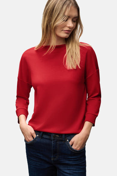 Top met korte mouwen rood van Street One, gedragen met een donkerblauwe spijkerbroek.