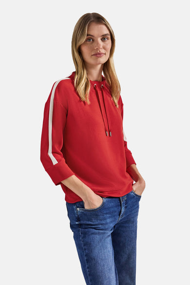 Sweat col rond rouge par STREET ONE, avec capuche à cordons et manches trois-quarts à rayures blanches, porté avec un jean.
