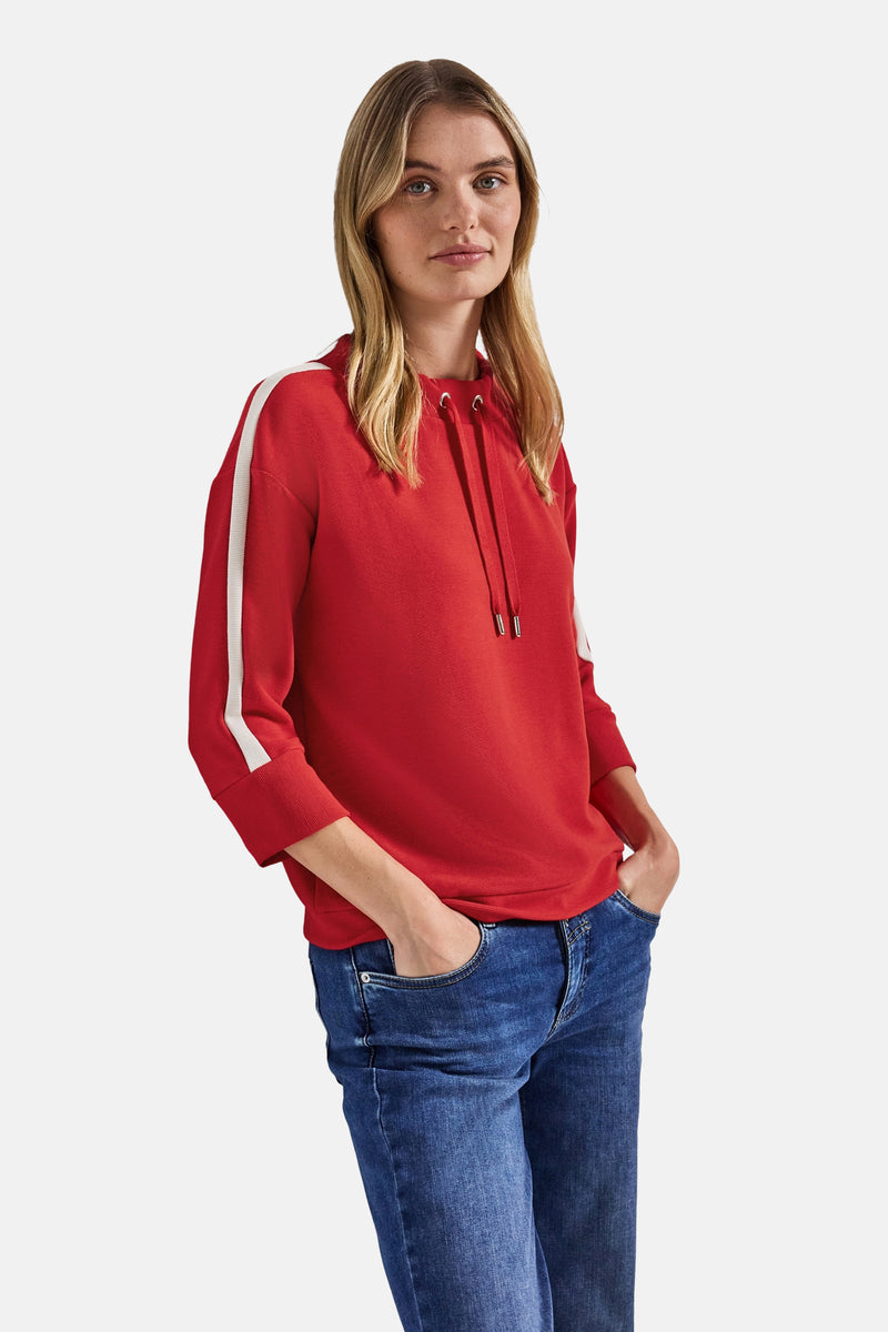 Sweat col rond rouge par STREET ONE, avec capuche à cordons et manches trois-quarts à rayures blanches, porté avec un jean.
