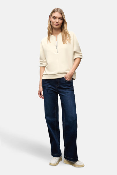 Beige sweater van STREET ONE, gedragen met een donkerblauwe jeans en witte sportschoenen.