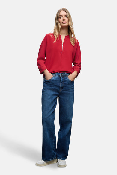 Rode sweater van STREET ONE, gedragen met een wijde blauwe jeans en witte sneakers.