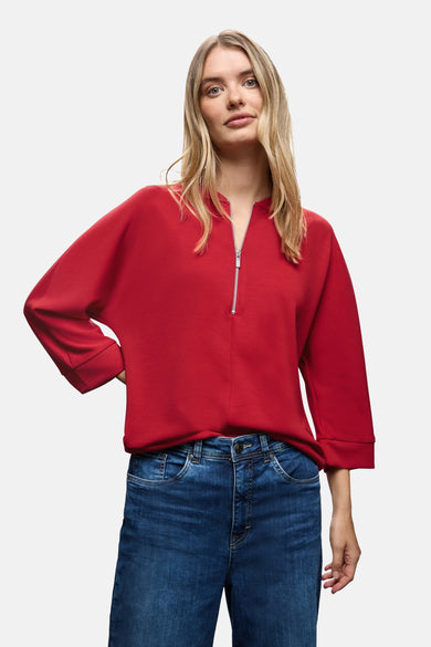 Rode sweater van STREET ONE gedragen met een blauwe spijkerbroek en een zilveren rits.