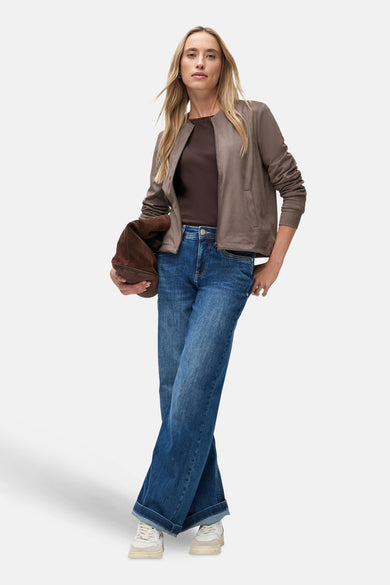 Bruine Street One-cardigan, gedragen met een T-shirt en een spijkerbroek, met een bruine handtas.