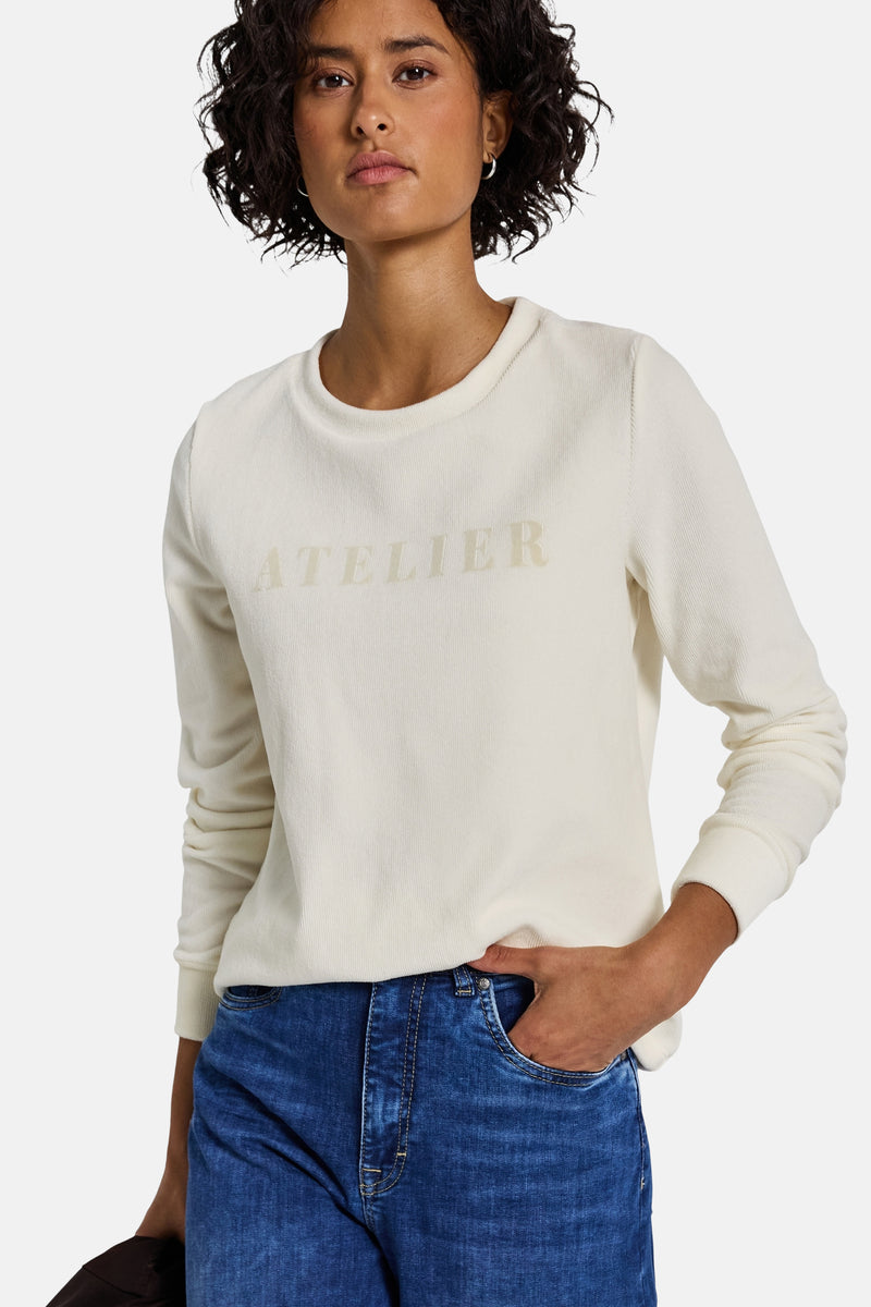 Ecru longsleeve top van Street One met "ATELIER" opschrift en gedragen met een blauwe jeans.
