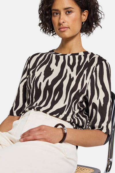 Bruin zebraprint T-shirt met korte mouwen, van STREET ONE, gedragen met een witte broek en een donkere armband.