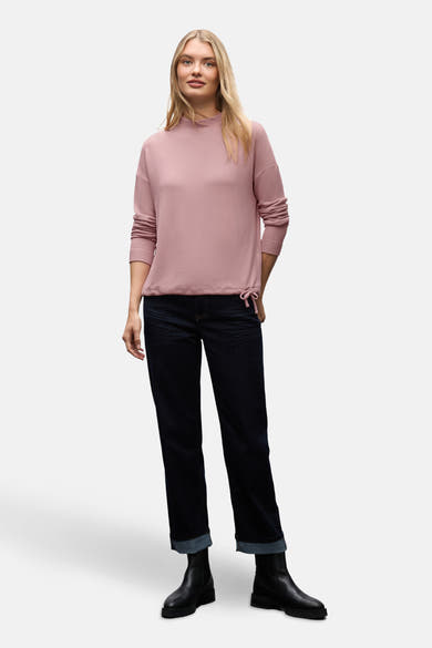 Pull col rond rose de Street One, porté avec un jean bleu foncé à revers et des bottines noires.
