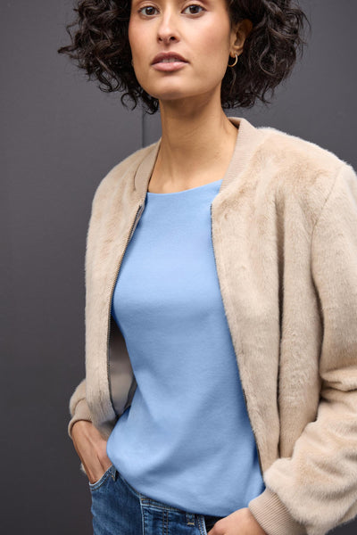 T-shirt à manches longues bleu de STREET ONE, porté avec une veste en fausse fourrure et un jean, modèle posant.
