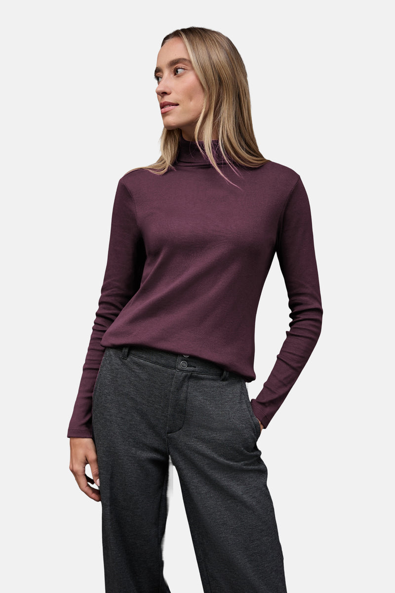 Top à manches longues rouge de Street One, porté avec un pantalon gris, femme regardant vers la gauche.