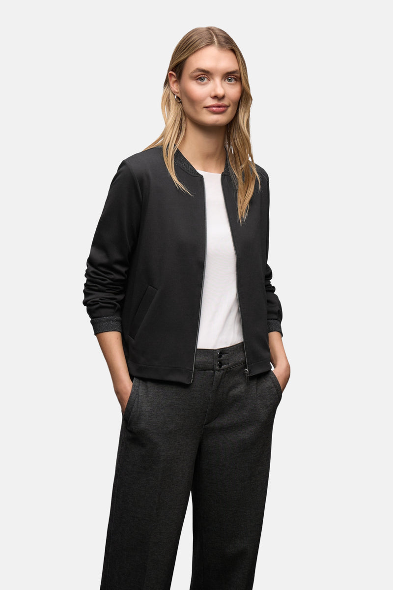 Gilet noir par STREET ONE, porté avec un t-shirt blanc et un pantalon gris anthracite.