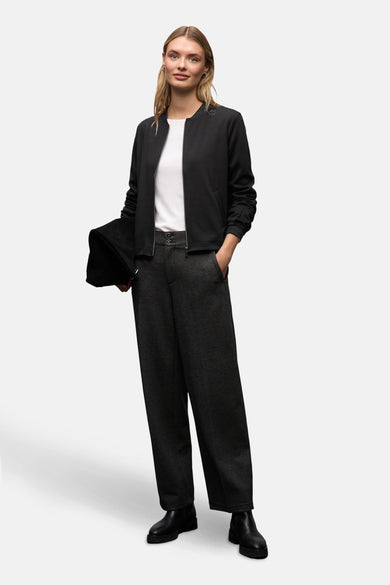 Gilet noir de STREET ONE, porté sur un t-shirt blanc simple avec un pantalon gris foncé à jambes larges.