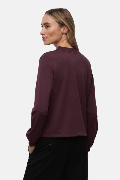 Gilet rouge de STREET ONE, porté avec un pantalon noir simple.
