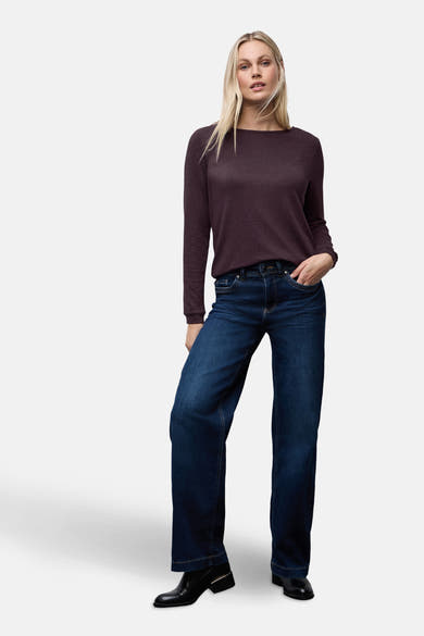 Top uni manches longues rouge de Street One, porté avec un jean taille haute et des bottines noires.
