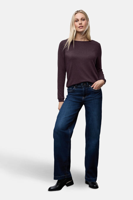 Top uni manches longues rouge de Street One, porté avec un jean taille haute et des bottines noires.
