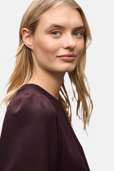 Sweat col rond rouge de Street One, porté par un mannequin blond sur fond neutre.