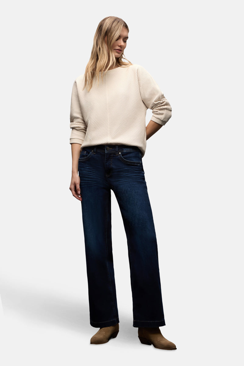 Top uni manches longues écru de STREET ONE, avec texture côtelée et coupe décontractée, porté avec un jean large et des bottines en daim.