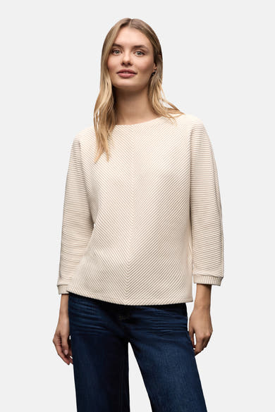 Top uni manches longues écru de STREET ONE, à texture côtelée et porté avec un jean bleu foncé.