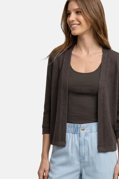 Gilet brun de STREET ONE, cardigan ouvert en tricot texturé, manches 3/4, porté sur un débardeur vert olive et un pantalon bleu clair.