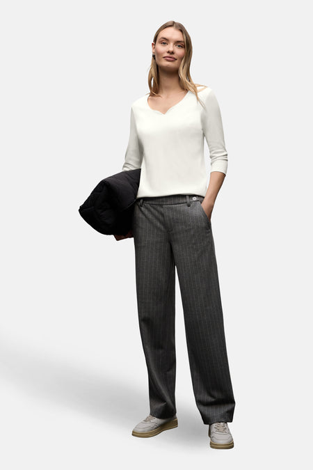 T-shirt blanc à manches courtes de Street One, porté avec un pantalon rayé gris, et une veste noire.