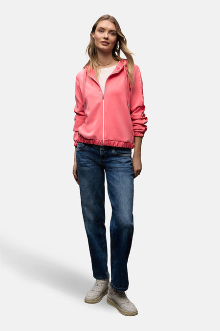 Gilet corail par STREET ONE avec fermeture éclair blanche, porté sur un t-shirt blanc et un jean bleu.
