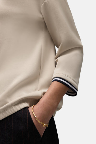 Beige sweater van STREET ONE met contrasterende strepen op de manchetten en gedragen met een gestreepte broek.