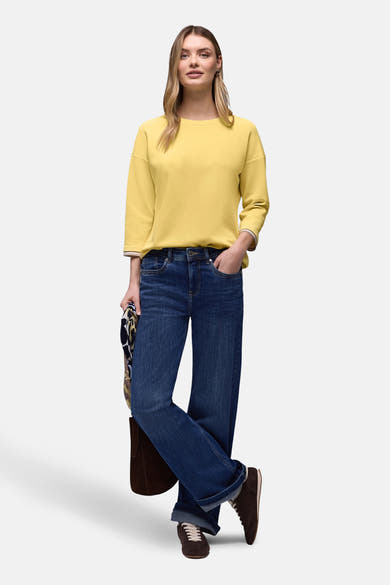 Sweat jaune de STREET ONE, manches trois-quarts avec bordure rayée, porté avec un jean ample et des chaussures marron.