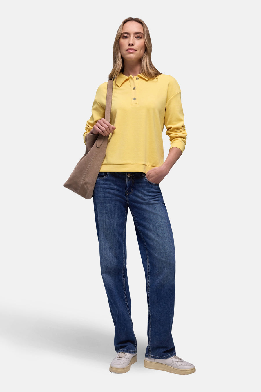 Sweat jaune de Street One, porté avec un jean bleu et un sac bandoulière en daim.
