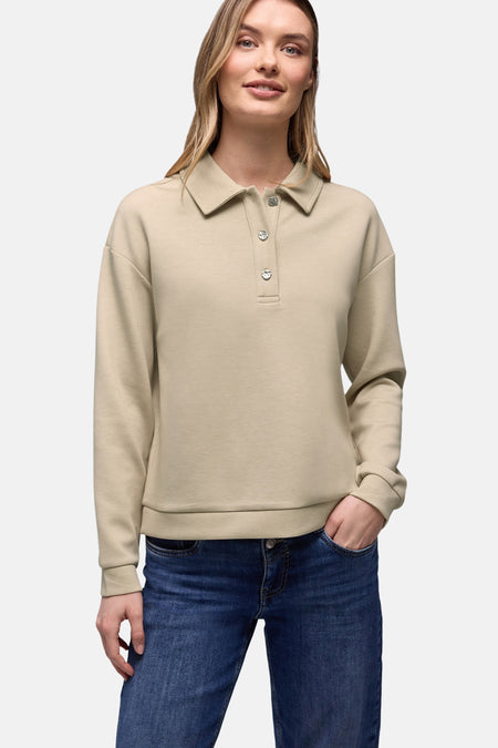 Sweat beige par STREET ONE avec un col polo à boutons argentés et un jean bleu.
