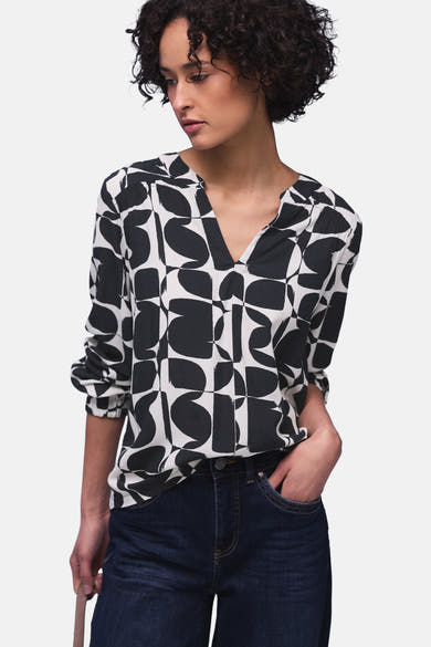 Multikleurige blouse van Street One, met geometrische patronen, gedragen met een donkerblauwe jeans en grijze schoenen.