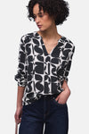 Multikleurige blouse van Street One, met geometrische patronen, gedragen met een donkerblauwe jeans en grijze schoenen.