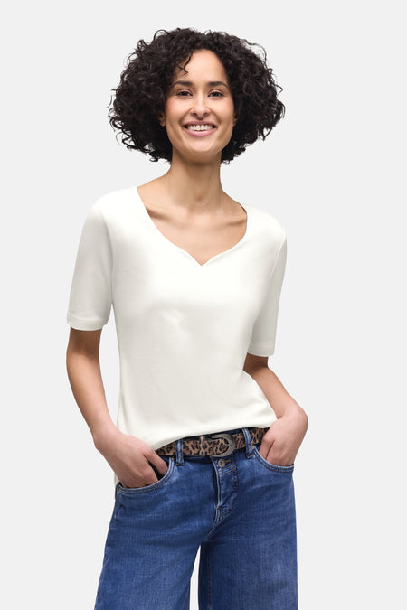 Wit T-shirt van STREET ONE, gedragen met een high-waisted jeans en een luipaardprint riem.