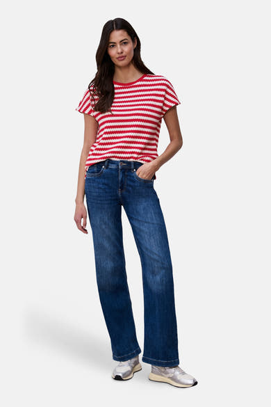 T-shirt multicolore de STREET ONE, à rayures horizontales rouges et blanches, porté avec un jean bleu et des baskets argentées.