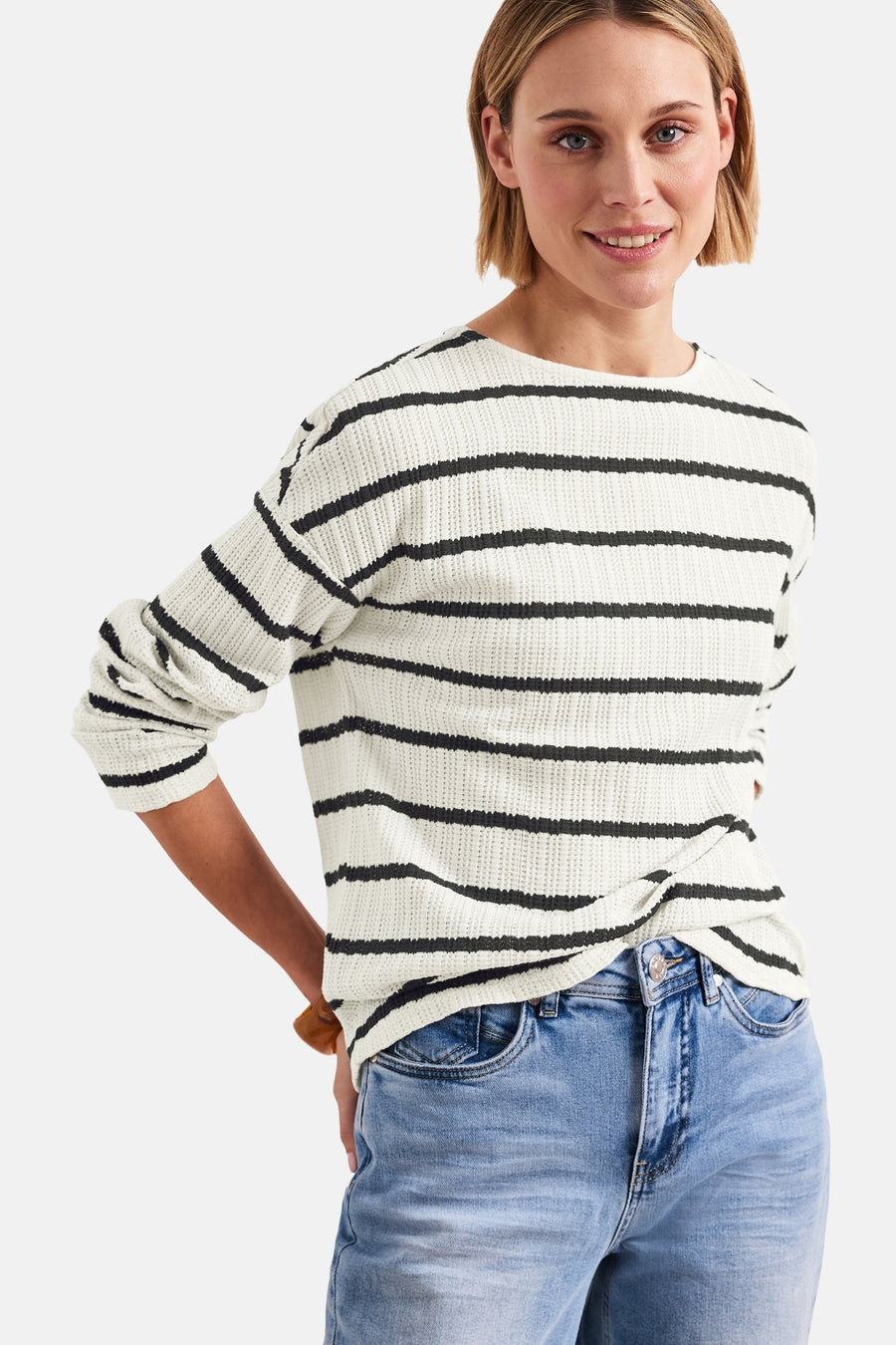 Pull à col rond multicolore de Street One, à rayures horizontales noires, porté avec un jean bleu.
