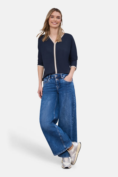 T-shirt bleu de STREET ONE avec bordure crème au col, porté avec un jean large bleu.
