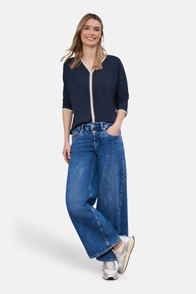 T-shirt bleu de STREET ONE avec bordure crème au col, porté avec un jean large bleu.
