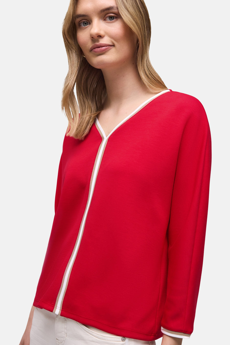 Effenchemise rood met lange mouwen van Street One, gedragen met een witte broek en een suède handtas.