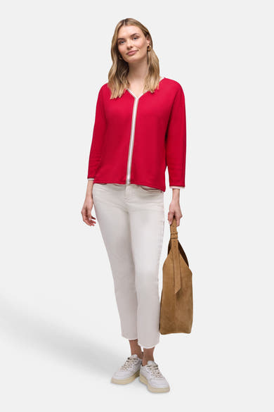 T-shirt rouge uni à manches longues de Street One, porté avec un pantalon blanc et un sac à main en daim.