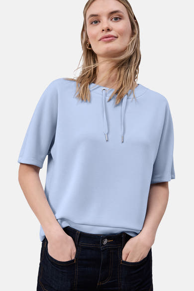 Blauwe sweater van STREET ONE met trekkoord in de hals en geribde boorden aan de mouwen, gedragen met een donkere jeans.