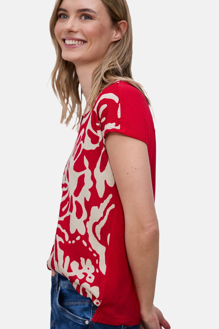 Blouse rouge à manches courtes de STREET ONE, avec motif abstrait blanc sur le devant, portée avec un jean bleu.