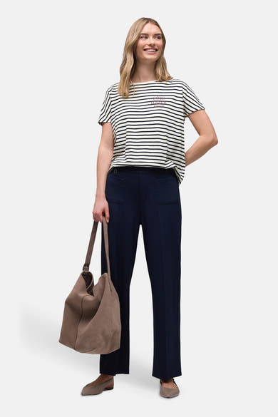 T-shirt à rayures multicolores de Street One, avec un imprimé rouge et porté avec un pantalon bleu marine et un sac marron.