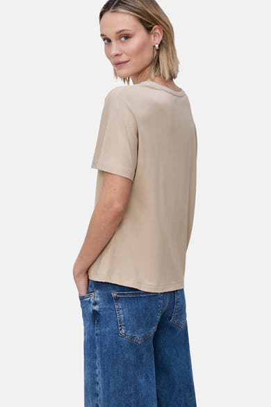 T-shirt uni beige à manches courtes de STREET ONE, porté avec un jean bleu par une femme vue de dos et de profil.