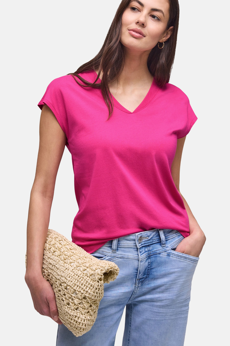 Roze T-shirt met V-hals en losse pasvorm van STREET ONE, gedragen met een lichte spijkerbroek en een rieten tas.