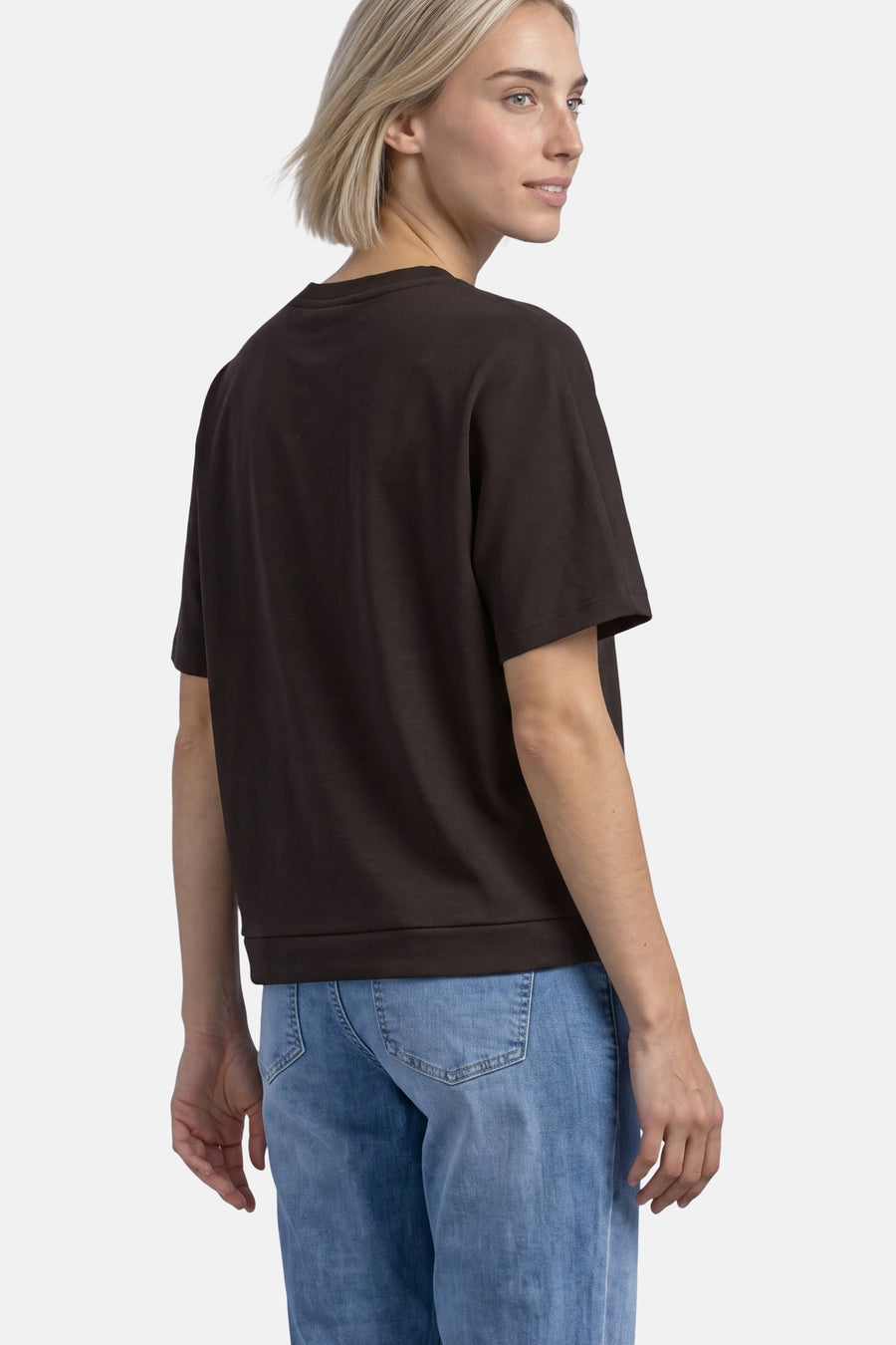 Brown crewneck sweatshirt with short sleeves and ribbed hem, worn by model in side view with light blue jeans.