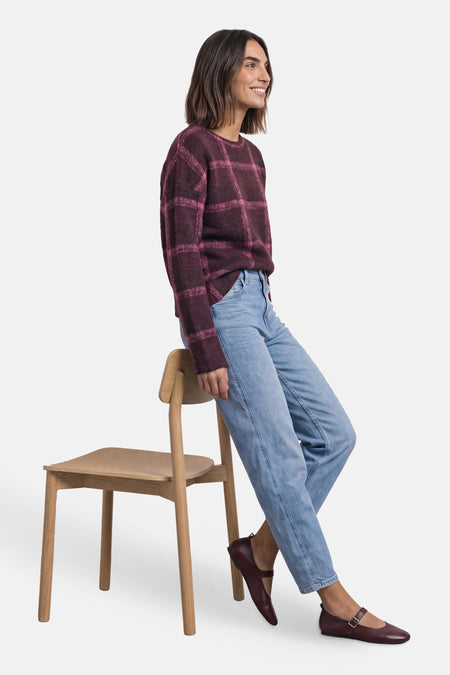 Pull col rond multicolore à motif quadrillé, porté par un mannequin assis sur une chaise – STREET ONE